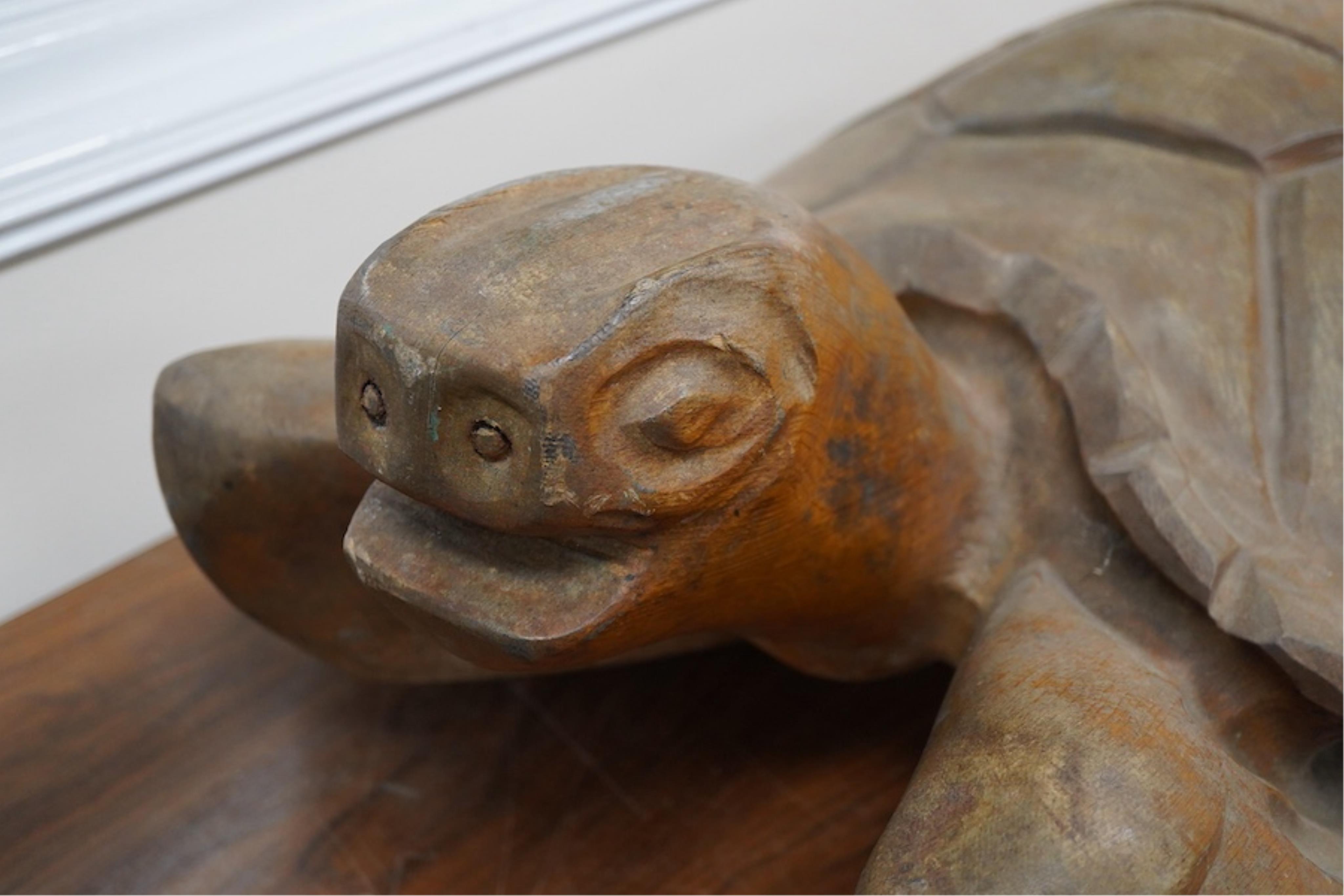 A large novelty carved weathered teak model of a green turtle